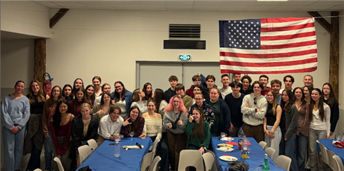 Ken-Ton students post with students in France with an American flag hanging in the background